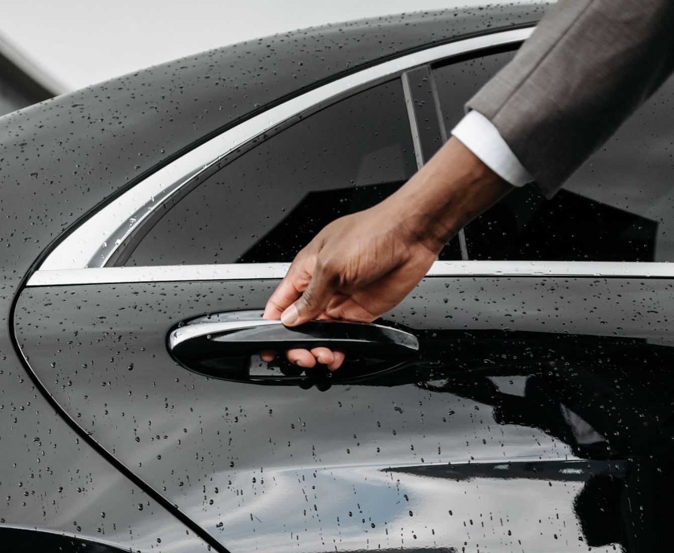El chófer abre la puerta del coche al cliente